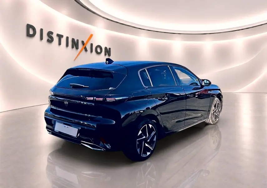 Peugeot 308 noire vue en 3/4 arrière droit dans un showroom avec jantes alliage et feux arrière LED.