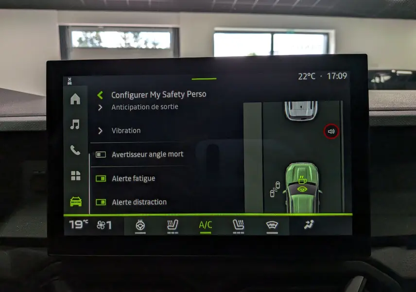 Écran tactile intérieur du Dacia Duster Hybrid-G blanc, affichant les réglages de sécurité et la climatisation.
