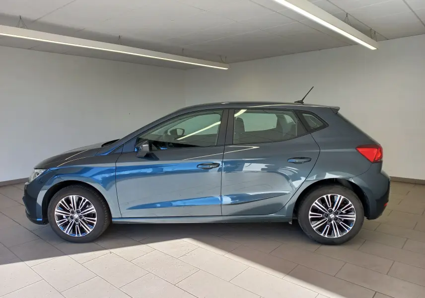 Vue de profil côté gauche d'une SEAT Ibiza 2025 gris magnétique, avec jantes alliage et antenne de toit visible.