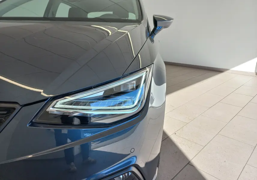 Gros plan sur le phare avant droit d'une SEAT IBIZA 2025 gris magnétique, mettant en valeur le design LED moderne.