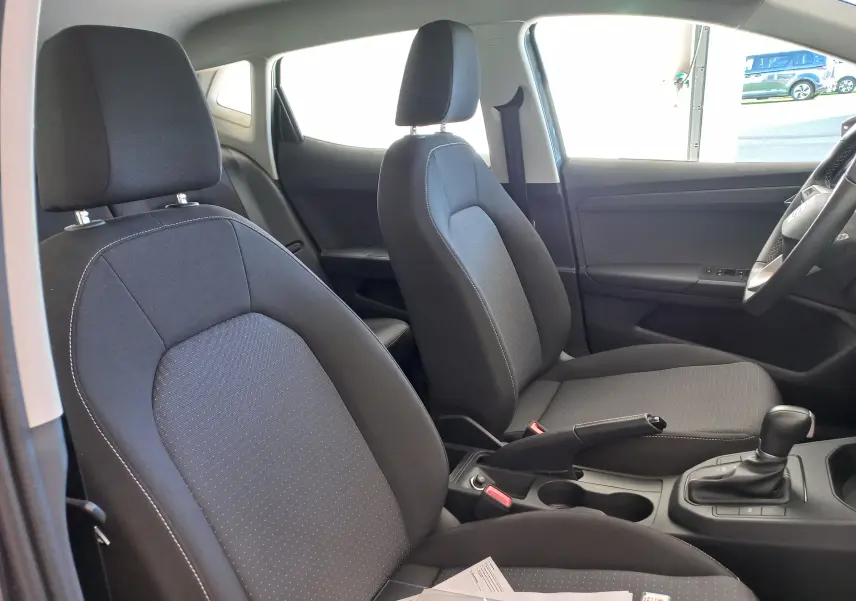 Vue intérieure côté droit du SEAT Ibiza 2025 avec sièges tissu gris foncé et boîte automatique visible.