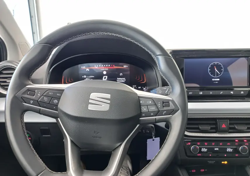 Vue intérieure centrée sur le volant du SEAT Ibiza 2025 avec tableau de bord digital et écran tactile.