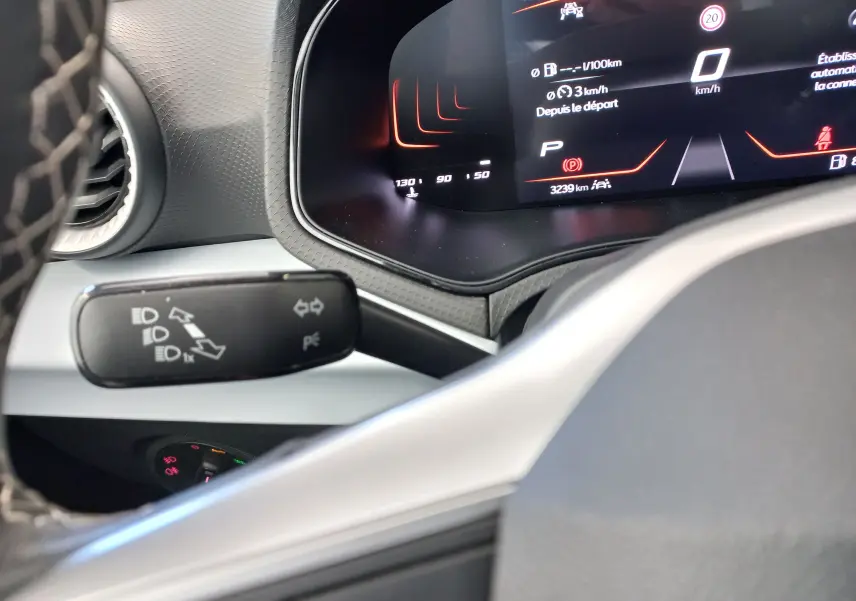 Tableau de bord numérique et commodo des feux dans l'habitacle d'une SEAT Ibiza gris magnétique 2025, vue rapprochée côté conducteur.