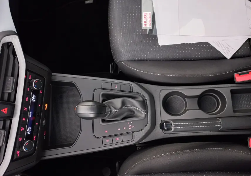 Vue intérieure centrée sur la console centrale de la SEAT IBIZA 1.0 TSI 115 DSG7 COPA avec levier de vitesse et sièges gris magnétique.