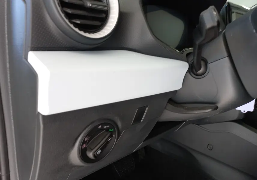 Détail intérieur côté gauche du tableau de bord de la SEAT IBIZA 2025 gris magnétique, avec commande d’éclairage et sortie d’air ronde.