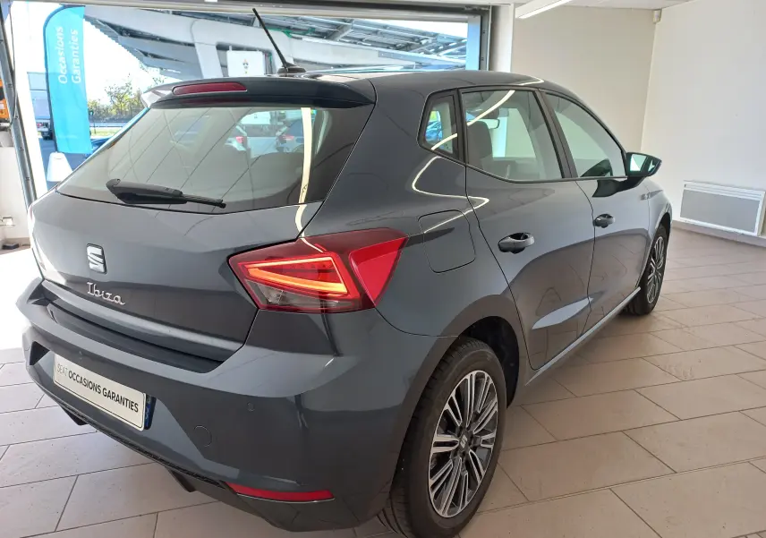 SEAT Ibiza 1.0 TSI 115 DSG7 Copa gris magnétique vue 3/4 arrière droit en intérieur showroom.