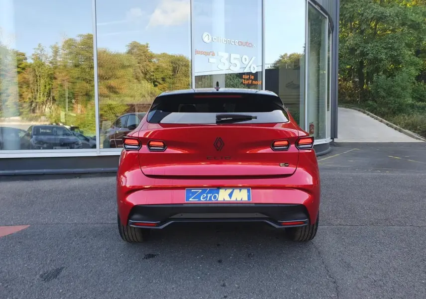 Vue arrière d'une Renault Clio VI rouge absolu avec feux LED distinctifs et plaque d'immatriculation Zéro KM.