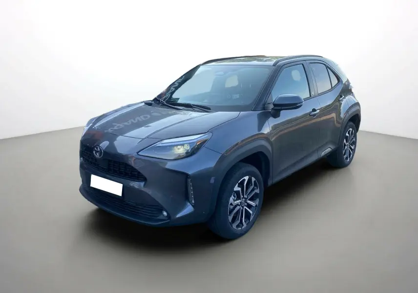 Toyota Yaris Cross hybride gris atlas vue 3/4 avant droit avec jantes alu 17 pouces et feux LED allumés.