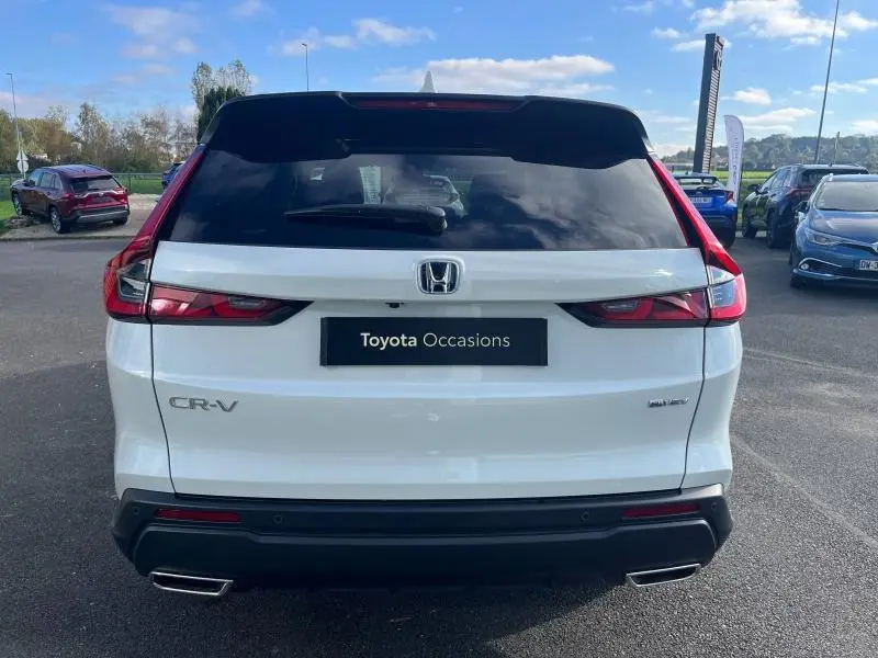 Vue arrière d'un Honda CR-V 2024 blanc Diamant Brillant Premium avec feux LED et double sortie d'échappement chromée.
