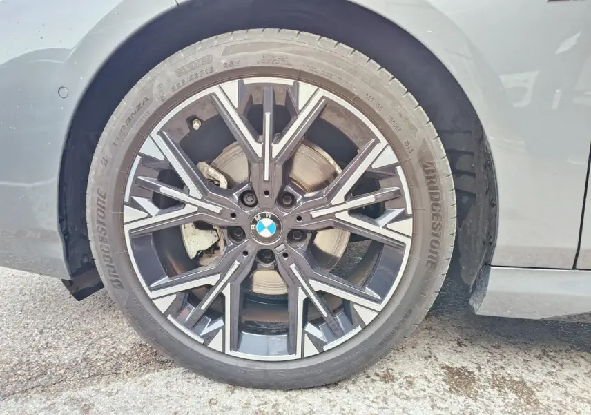 Gros plan sur l'aile avant droite grise Skyscraper d'une BMW Série 1 M Sport avec logo M coloré visible.