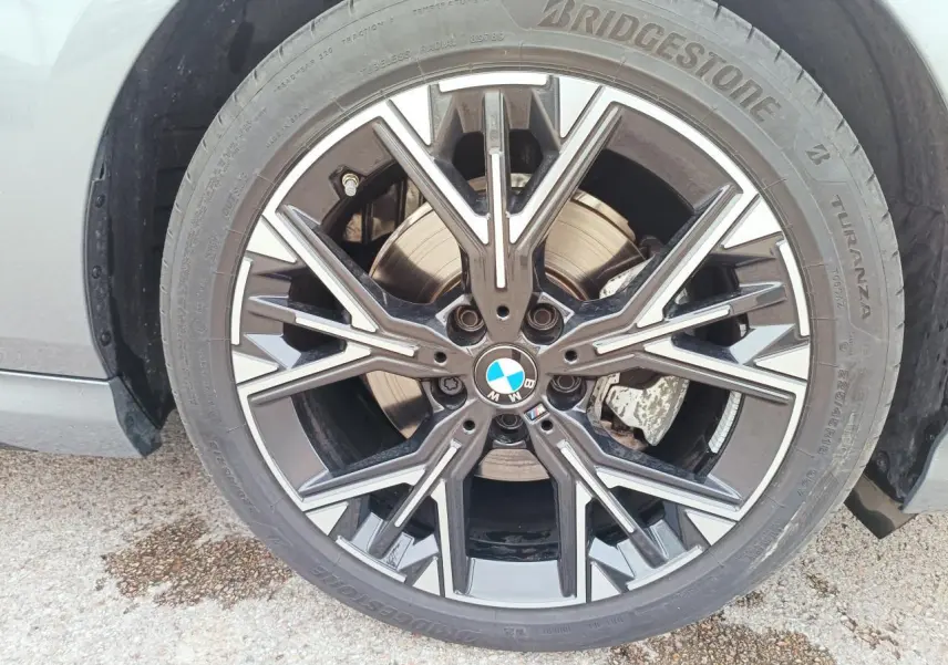 Gros plan sur la roue avant droite de la BMW Série 1 gris Skyscraper avec jante alliage M bicolore et logo BMW au centre.