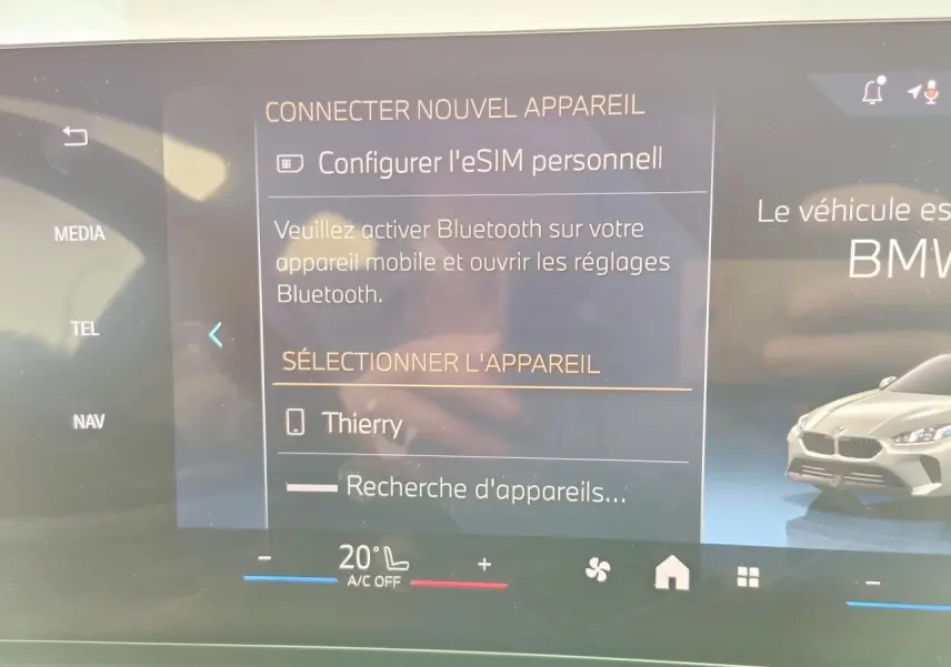 Écran tactile du système BMW Live Cockpit affichant la connexion Bluetooth et une image de BMW Série 1 gris Skyscraper en 3/4 avant droit.