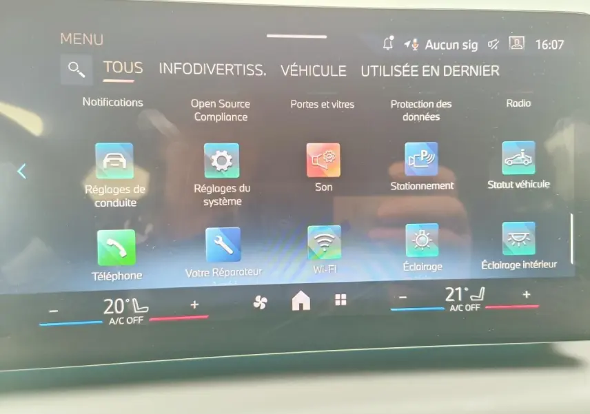 Écran tactile intérieur de la BMW Série 1 2025 affichant le menu principal avec options connectées et climatisation bi-zone.
