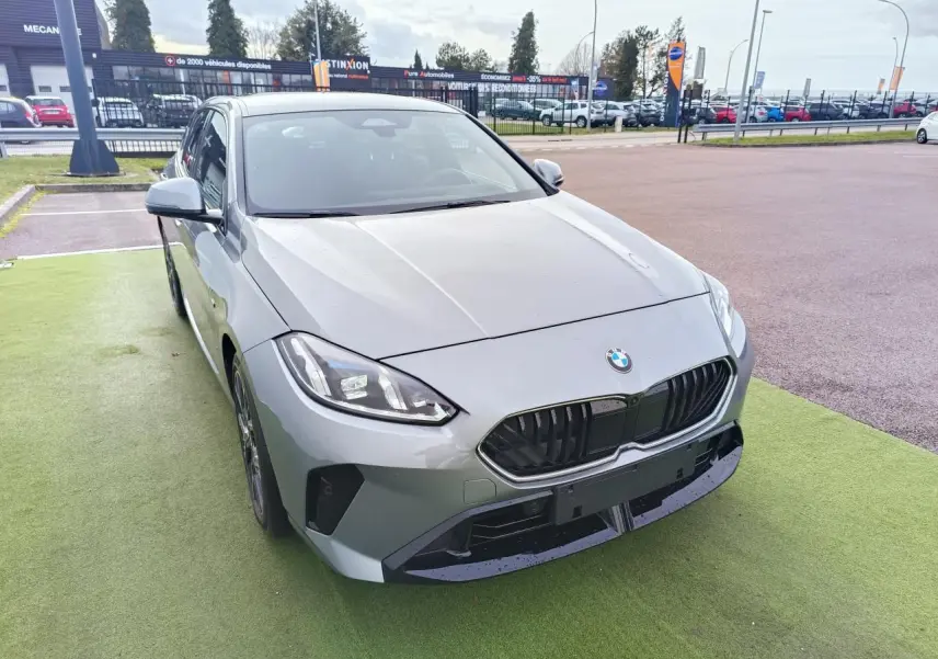 BMW Série 1 gris Skyscraper vue 3/4 arrière droit, toit noir et jantes alliage 18 pouces M Sport.