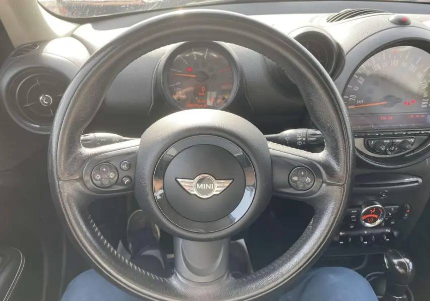 Vue plongeante sur le volant cuir noir et le tableau de bord du MINI Countryman gris clair de 2015.