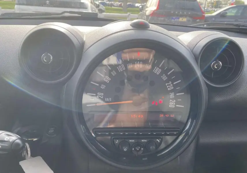 Vue rapprochée du tableau de bord de la MINI Countryman 2015, avec compteur central et aérateurs ronds noirs.