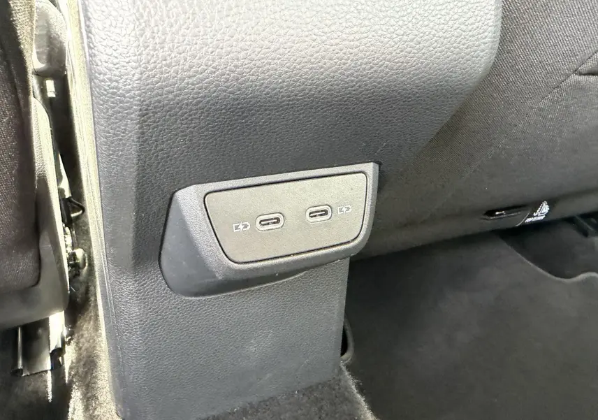 Prise USB-C double en gros plan sur la console arrière du Volkswagen Taigo, intérieur noir.