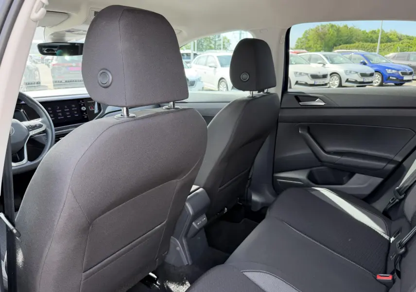 Vue intérieure arrière du Volkswagen Taigo 2025 montrant les sièges noirs et la portière côté droit.