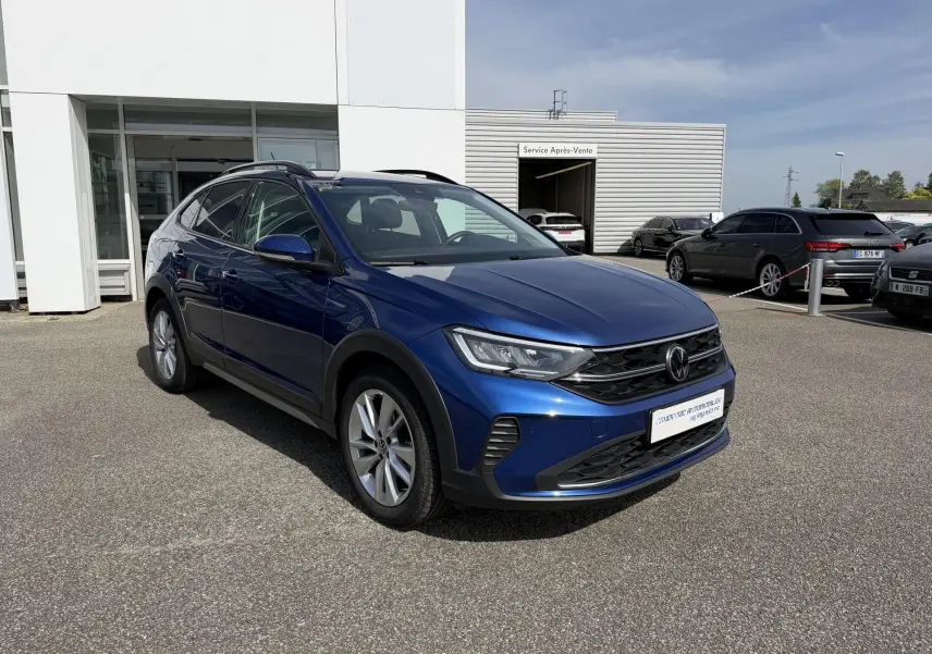 Volkswagen Taigo bleu métallisé en 3/4 avant droit, avec jantes alliage et calandre noire distinctive.