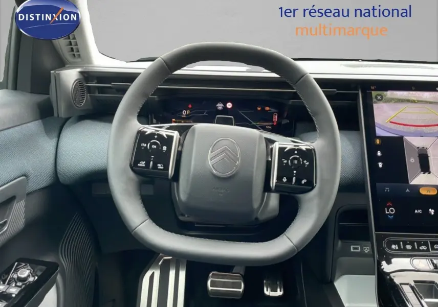 Vue intérieure centrée sur le volant du Citroën C5 Aircross 2026, avec tableau de bord numérique et écran tactile visible.