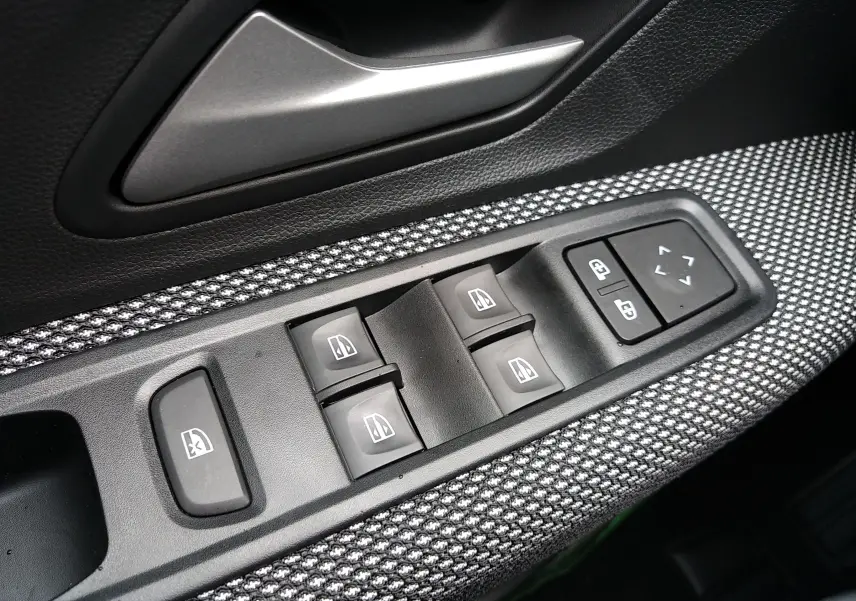 Panneau de commandes des vitres électriques côté conducteur dans l'habitacle d'une Dacia Sandero 2025 finition Expression+