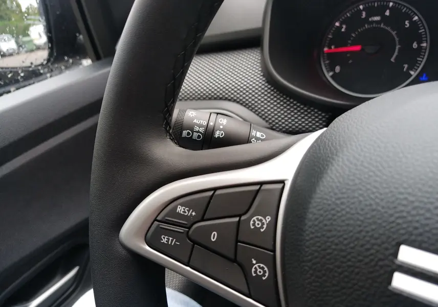 Gros plan sur le volant côté gauche de la Dacia Sandero 2025, avec commandes de régulateur de vitesse visibles.