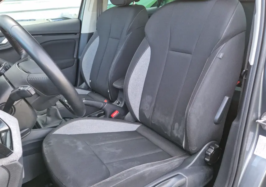 Vue intérieure côté conducteur du Skoda Kamiq 2024, sièges tissu gris noir avec surpiqûres contrastées.