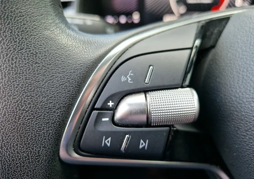 Gros plan sur les commandes argentées et noires du volant du Skoda Kamiq 2024, finition gris graphite métal.