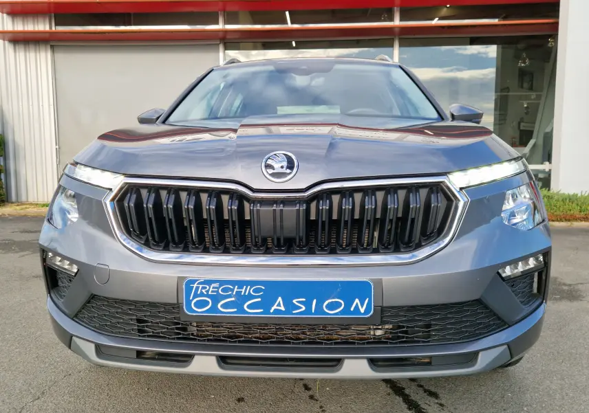 Vue frontale d'un Skoda Kamiq gris graphite métallisé avec calandre noire et plaque d'occasion bleue.