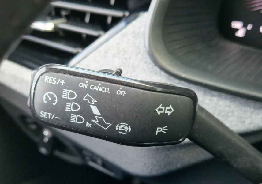 Gros plan sur la commande de régulateur de vitesse et clignotants dans l'habitacle d'un Skoda Kamiq gris graphite 2024.