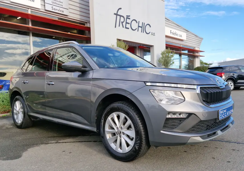 SKODA KAMIQ gris graphite métal vu en 3/4 avant droit, mettant en valeur sa calandre noire et ses phares LED distinctifs.