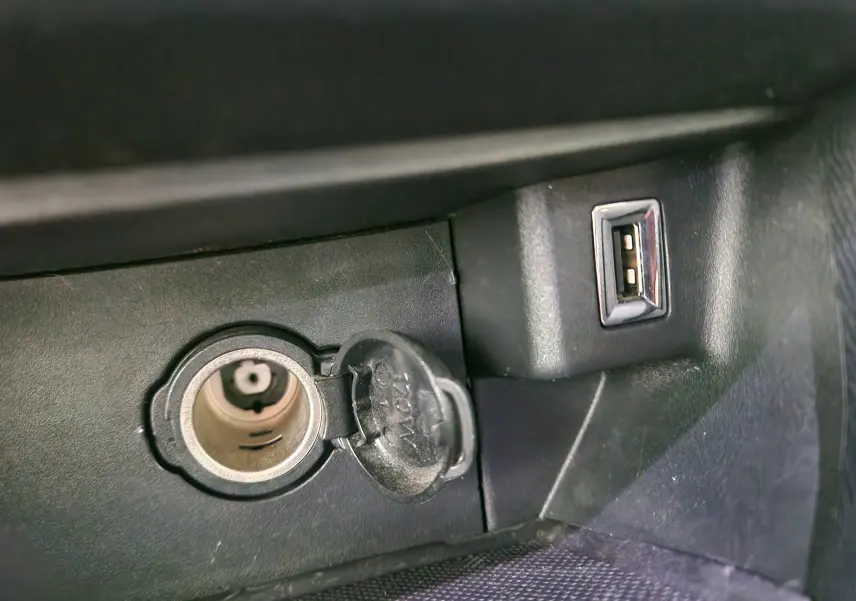 Prise allume-cigare et port USB intégrés dans la console centrale d'une Peugeot 308 SW gris Artense.