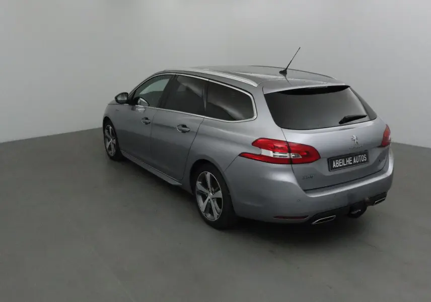 Peugeot 308 SW gris Artense vue 3/4 arrière droit, vitres teintées et jantes alliage 17 pouces visibles.