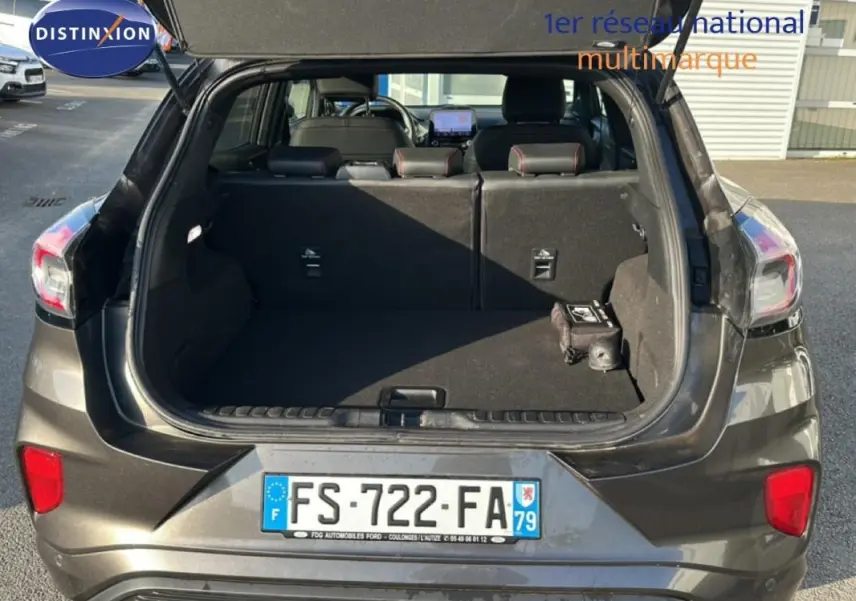 Vue arrière ouverte du coffre d’un Ford Puma gris foncé 2020, montrant l’espace de chargement et les sièges arrière.