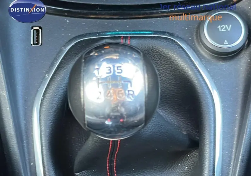 Gros plan sur le levier de vitesses manuel noir avec surpiqûres rouges dans une Ford Puma gris foncé de 2020.