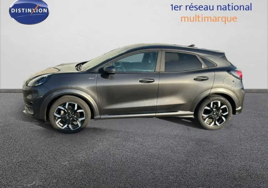 Vue de profil côté gauche d’un Ford Puma gris foncé avec jantes alliage 18 pouces sur fond neutre.