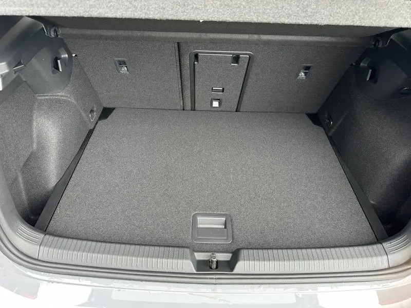 Coffre ouvert vu de l'arrière d'une Volkswagen Golf 2.0 TDI gris 2026, avec revêtement intérieur noir et espace de rangement plat.