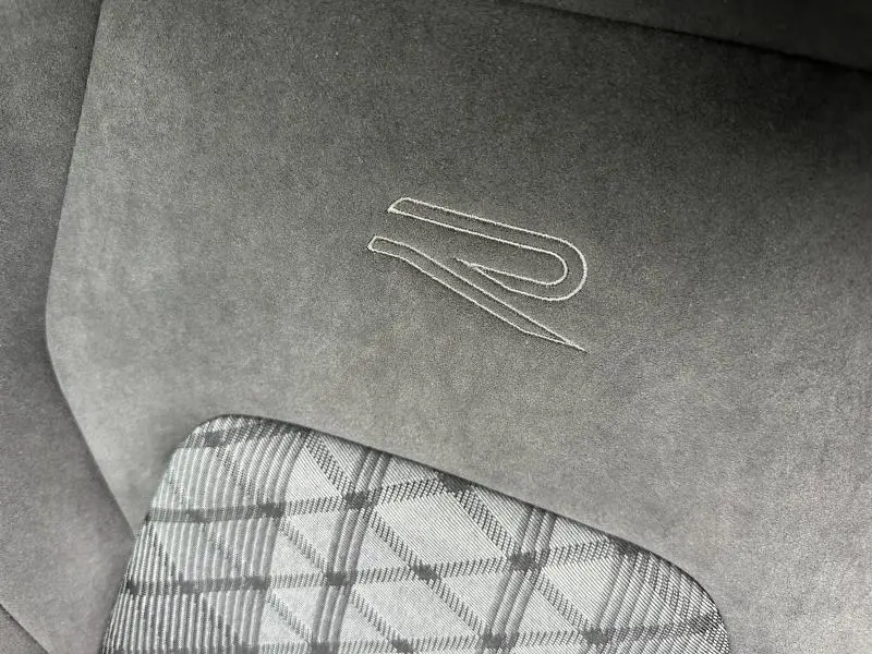Détail de l’assise en tissu à motif écossais et de l’appuie-tête en alcantara gris avec logo R brodé de la Volkswagen Golf 2.0 TDI 150ch R-Line 2026.