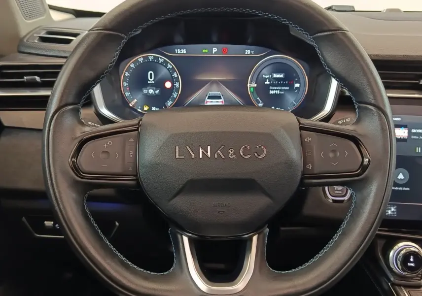 Vue rapprochée du volant noir avec logo Lynk & Co et tableau de bord numérique affichant les instruments.