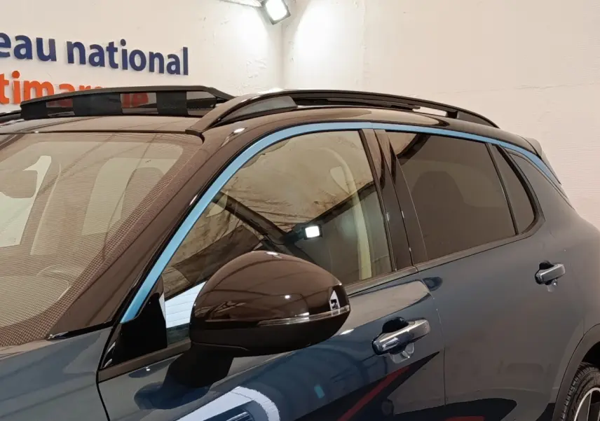 Vue latérale droite du SUV LINK & CO 01 bleu avec toit ouvrant et rétroviseur noir brillant.