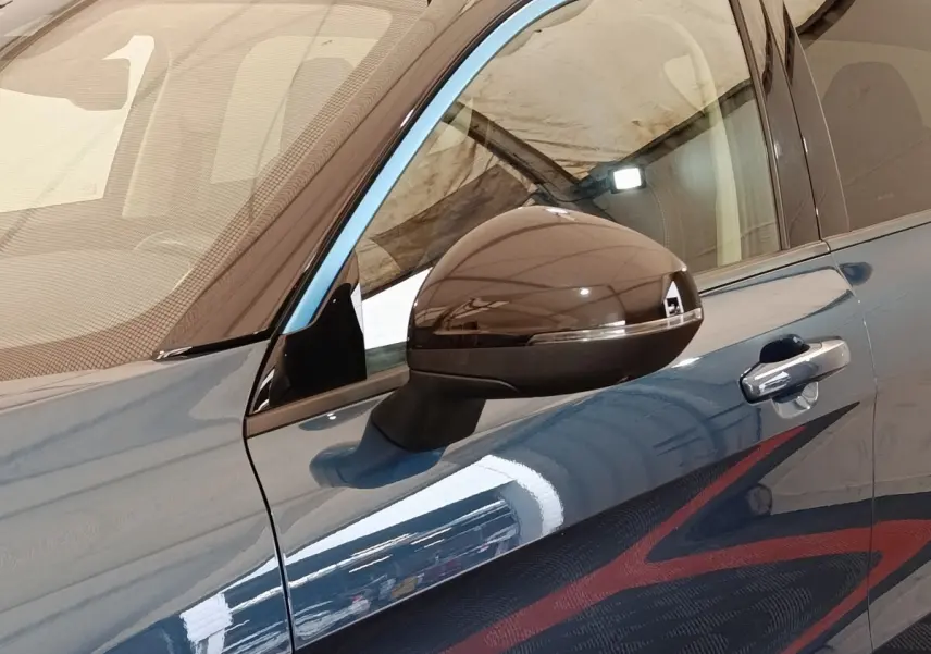 Vue rapprochée du rétroviseur droit et de la portière bleu métallisé du SUV Link & Co 01 hybride rechargeable 2023.