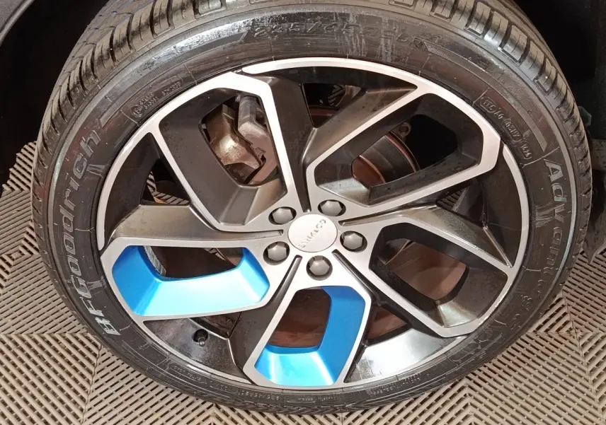 Gros plan sur la jante avant droite noire et bleue du SUV hybride rechargeable LINK & CO 01 bleu 2023.