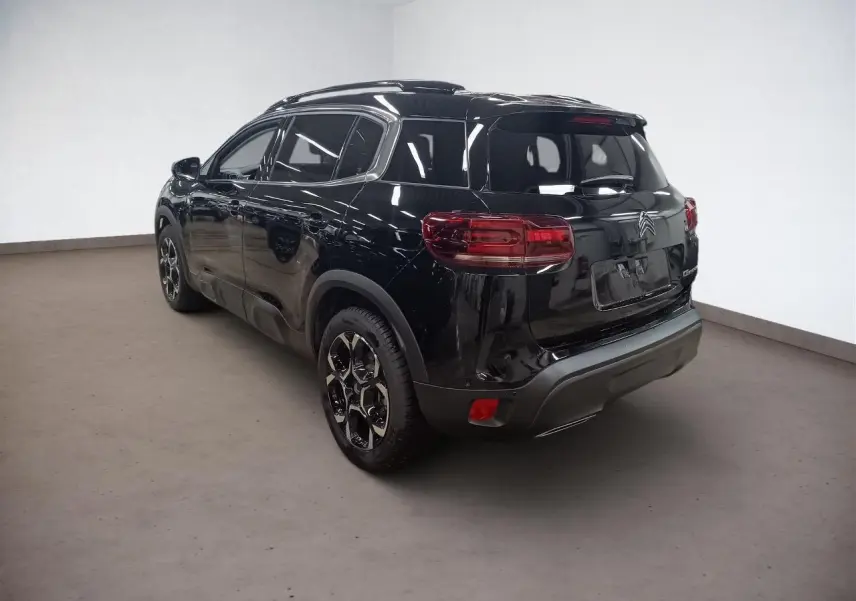 Vue 3/4 arrière droite d'un Citroën C5 Aircross Hybrid noir Perla avec jantes alliage bi-ton et hayon électrique.