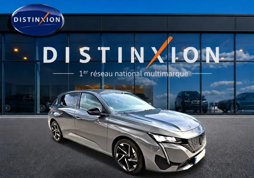 Peugeot 308 gris selenium vue 3/4 avant droit, avec phares LED et jantes alliage distinctives.