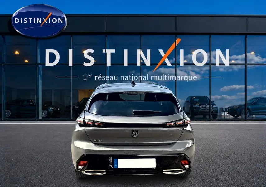 Vue arrière d'une Peugeot 308 gris selenium 2025, avec feux arrière LED et double sortie d'échappement chromée.