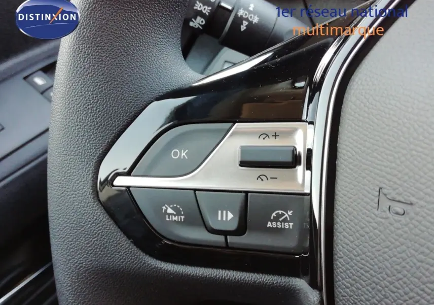 Gros plan sur les commandes au volant côté gauche du Peugeot Partner 2026, finition noire et argentée.