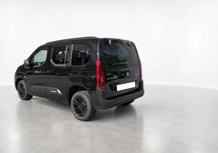 Vue 3/4 arrière gauche du Citroën Berlingo noir perla nera avec vitres surteintées et jantes noires.