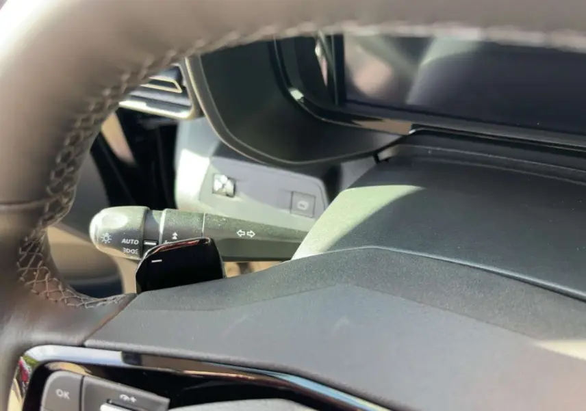Gros plan sur le volant cuir et la commande des clignotants du Citroën Berlingo noir perla nera, intérieur moderne.