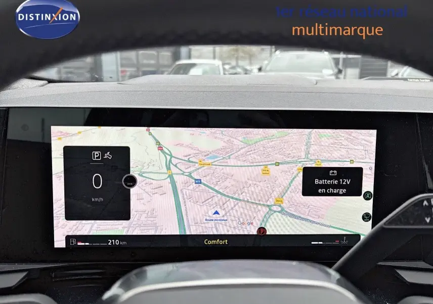 Vue rapprochée de l'écran numérique du tableau de bord du Renault Austral noir étoile métal, affichant la navigation et l'état de la batterie.