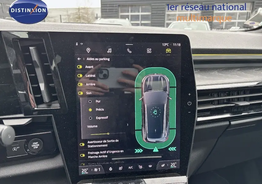 Vue intérieure centrée sur l'écran tactile du tableau de bord du Renault Austral noir étoile métal, affichant l'aide au parking.